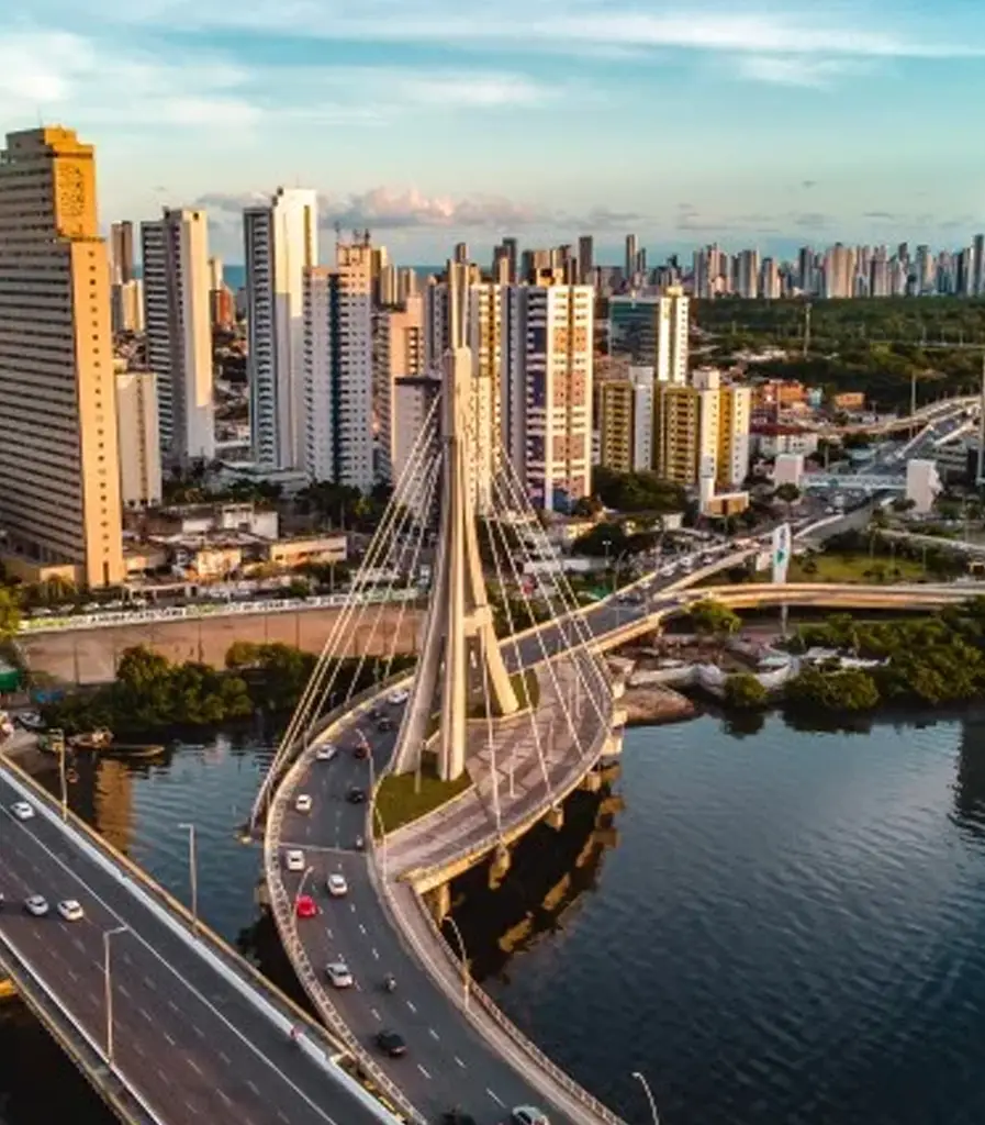 Vista aérea da ponte estaiada sobre o rio e prédios do Recife